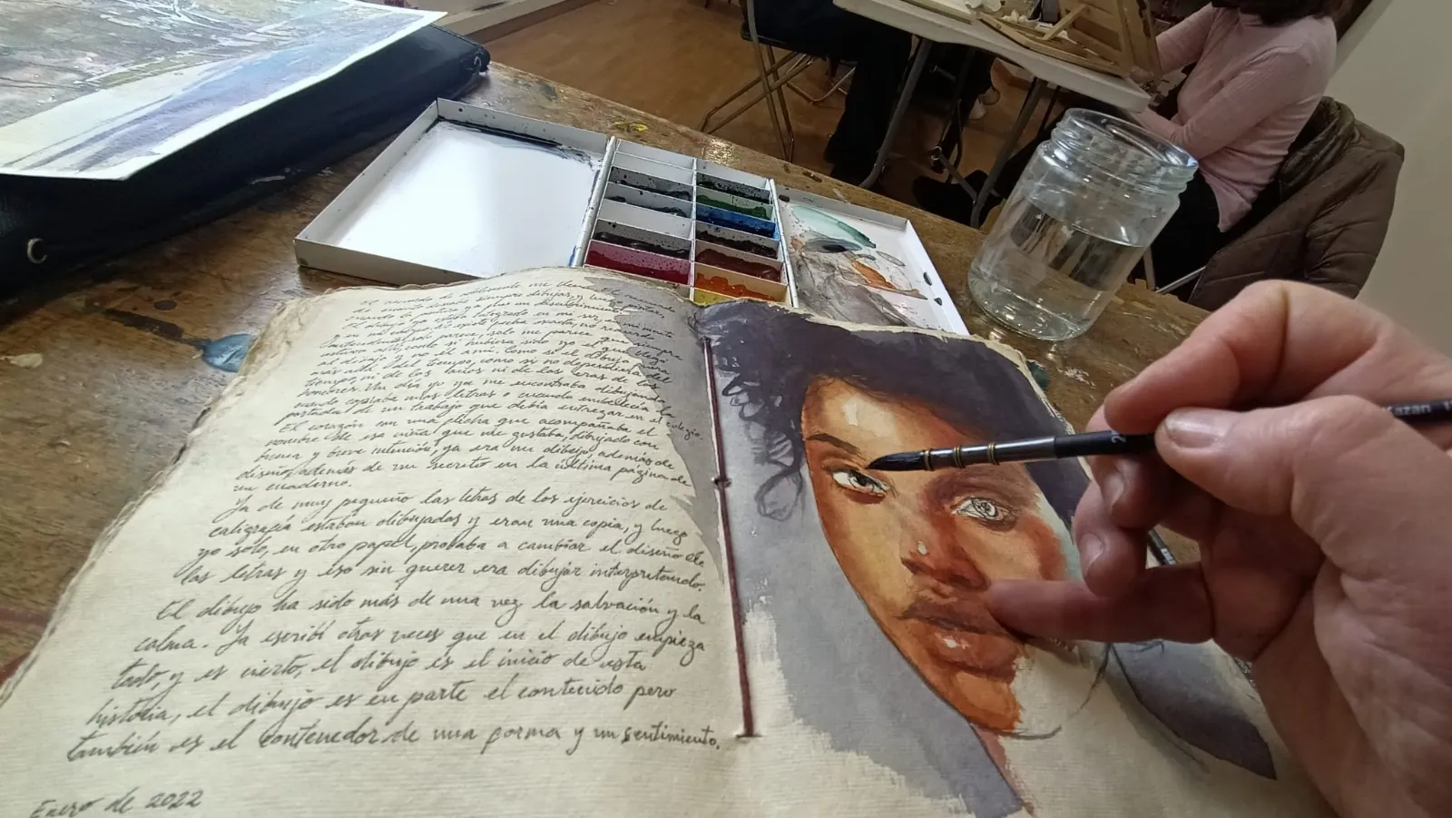 Emmanuel Luna pintando un retrato en acuarela en su cuaderno
