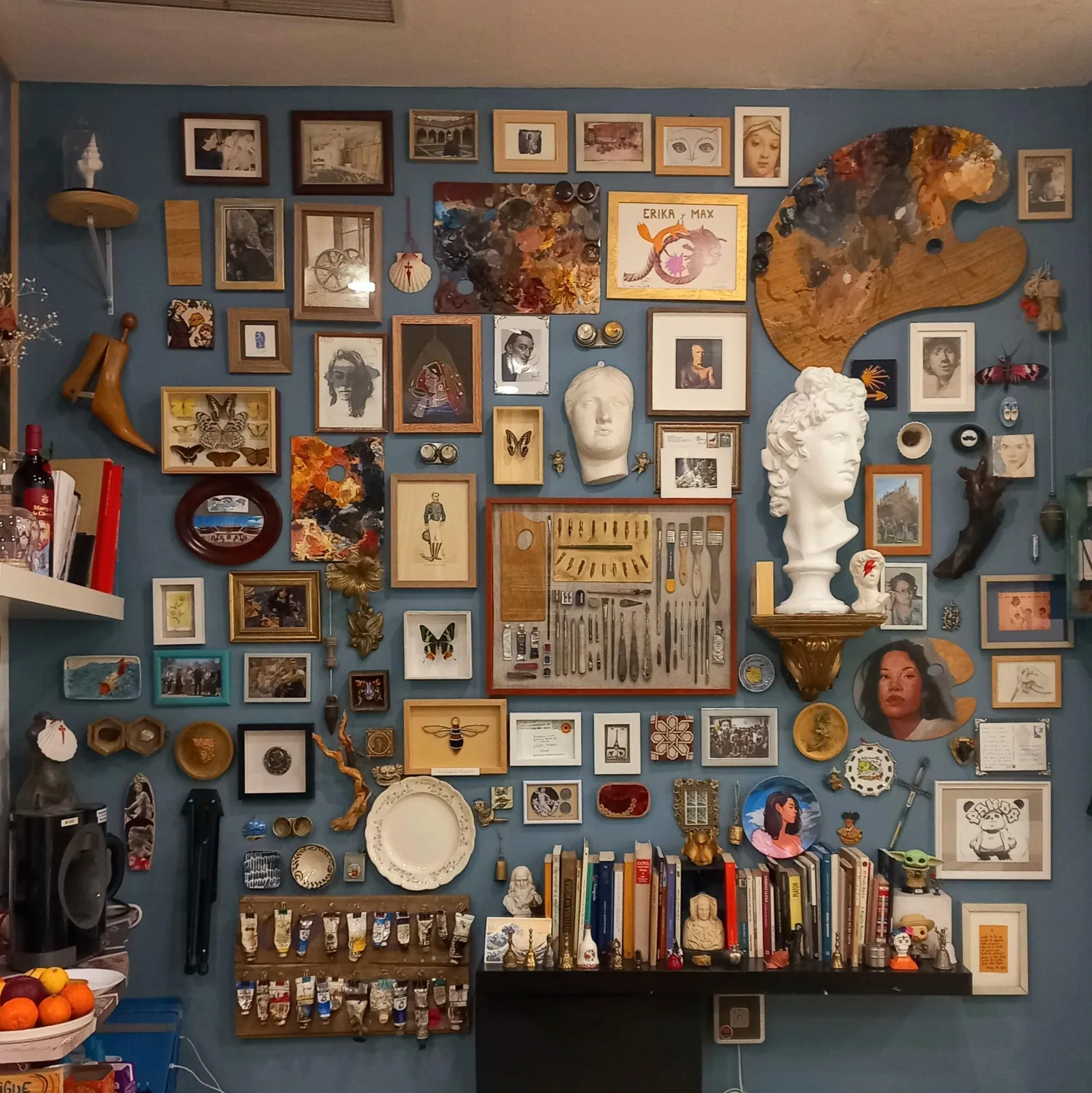 Detalle de la pared de cuadros con un busto de yeso